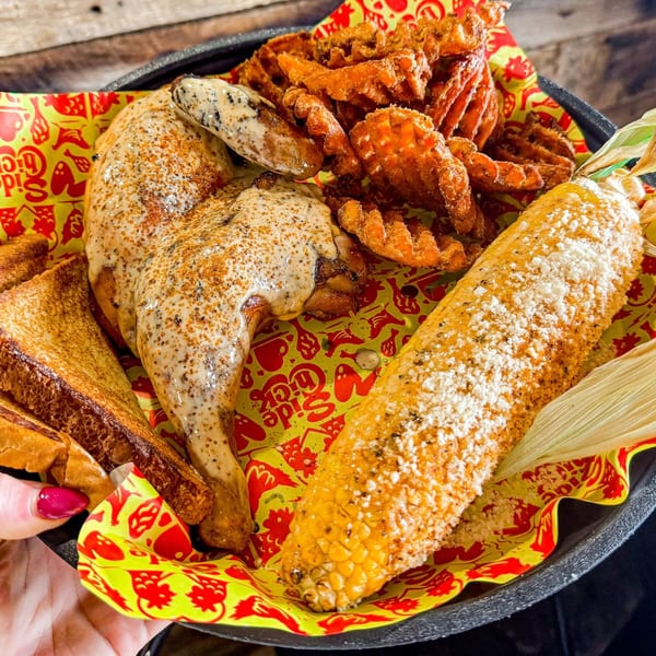 A Side Chick chicken meal with waffle fries, buttered toast, and corn on the cob.